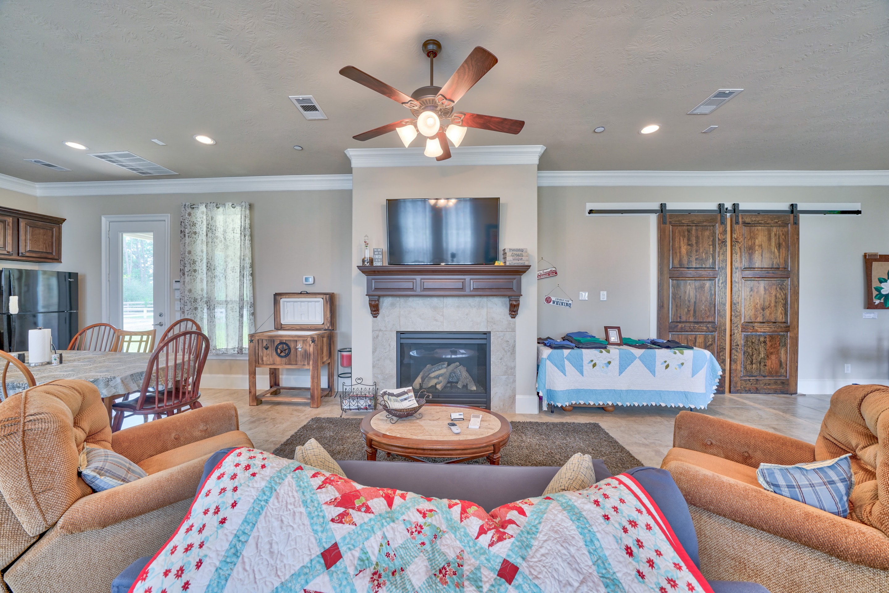 Sitting area with fireplace, ceiling fan, barn doors, and comfortable seating