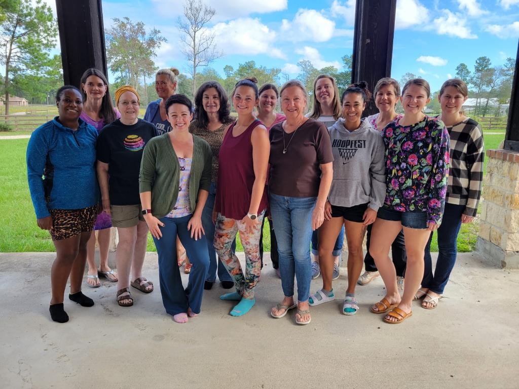 Group of women gathered under the covered outdoor porch area at Magnolia Manor Retreat