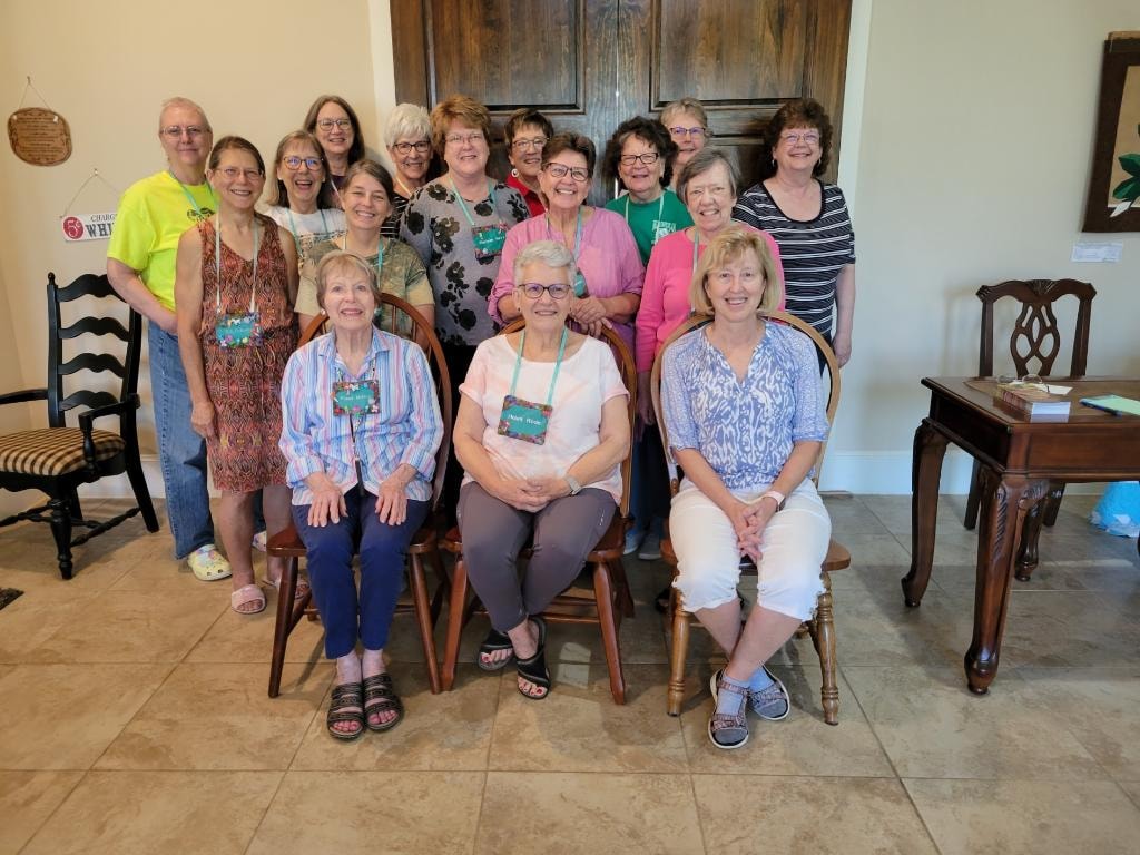 Group of women posing together in the sitting area during a quilting retreat at Magnolia Manor