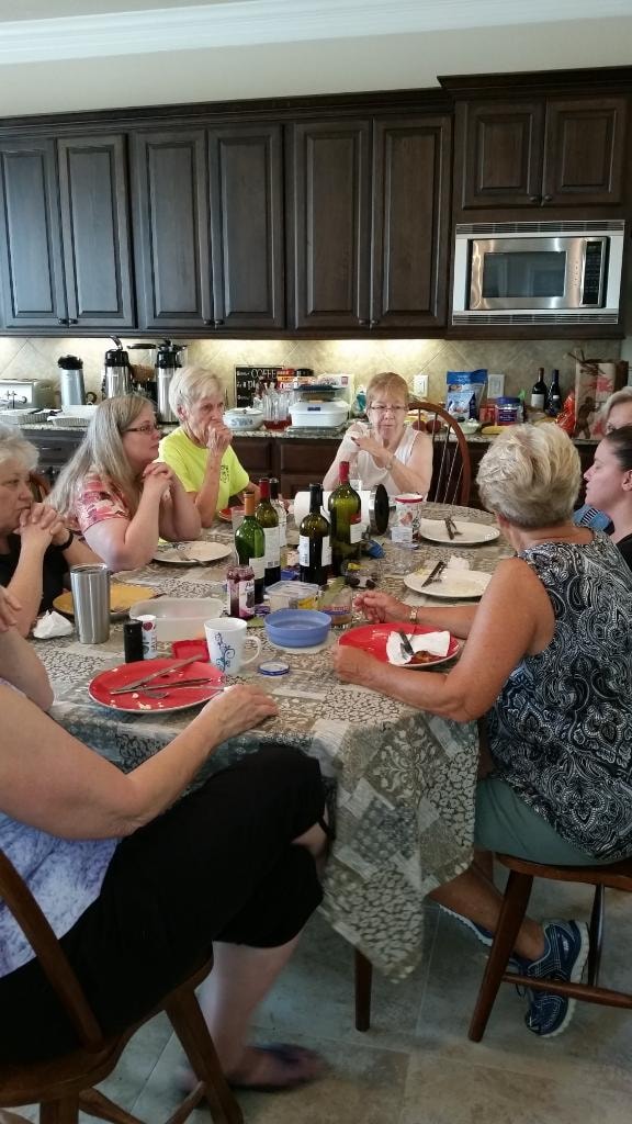 Group of women enjoying a dinner together with wine bottles on the table at Magnolia Manor